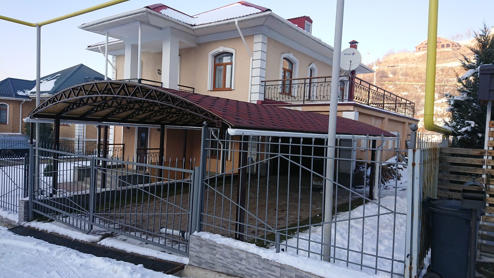 Металлические ворота и ограждение рядом с навесом